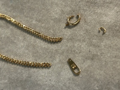 ネックレスの留め具（引き輪）と外れた極細の丸環（マルカン）の拡大写真