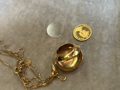 外れてしまったコインと透明カバー、ゴールド製ロケット本体の全体写真