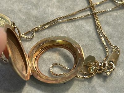 ふたを開いたゴールドロケット内部の受け部分を確認している写真