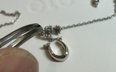 工具を使って絡まったチェーンを慎重にほどいている作業写真