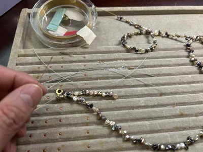 定規の上に置かれた黒いネックレス