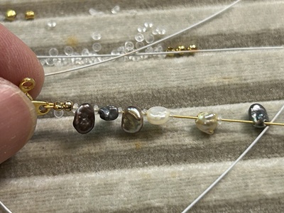 新しいワイヤーに黒い石を通していく作業