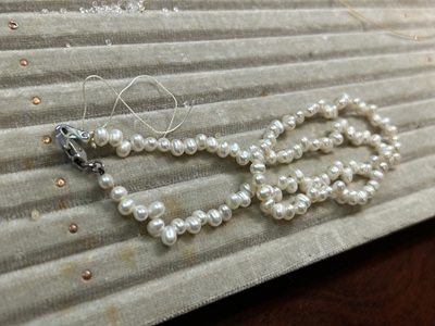 透明な石のネックレスを定規で測る様子