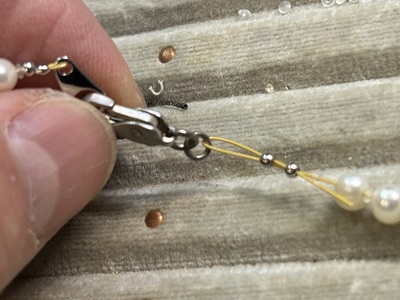 透明な石のネックレスの留め具の仕上げ作業