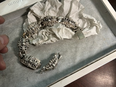 ケースの中に置かれたブレスレット全体と、取り外したコマパーツ。