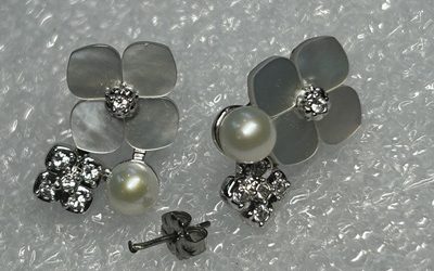 修理完成後の花モチーフ・パール・ダイヤモンドピアス2個を正面から撮影、新しいキャッチ付きで左右対称に並んでいる
