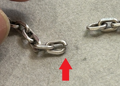 切れたチェーン接続部分を赤い矢印で示した拡大写真