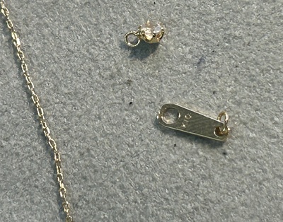 切れてしまったゴールドのネックレスと金具のクローズアップ