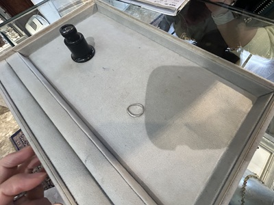 修理を待つ、小傷のついた変形した結婚指輪のアップ