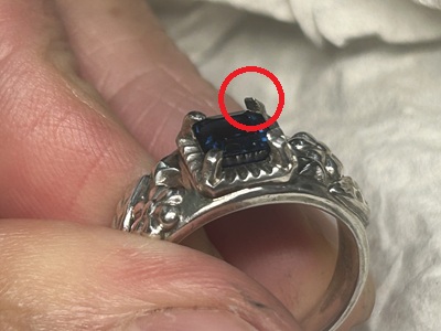 爪留め工具を使い、石の爪を倒して固定する様子