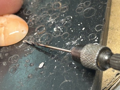 極細ドリルを使って珊瑚の穴の内部を掃除する職人の手元