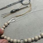 4連のオペロンゴムが全ての珠に通し終えられ工具が置かれた作業台