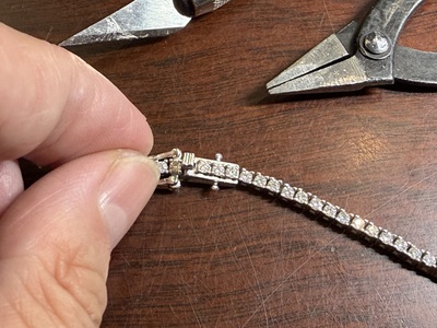 鋭敏なカッターや工具を用いてブレスレットの差し込みバネを精密修正する様子