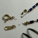 取り外された金具類と分解・解体が進められているネックレスパーツ