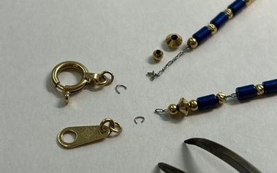 取り外された金具類と分解・解体が進められているネックレスパーツ