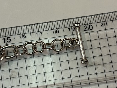 加工が完了し定規の上で19cmを指しているシルバーブレスレット全体画像