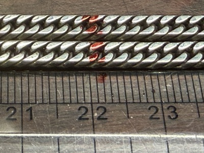 定規を当ててチェーンのカット位置を正確に計測・マーキングしている様子